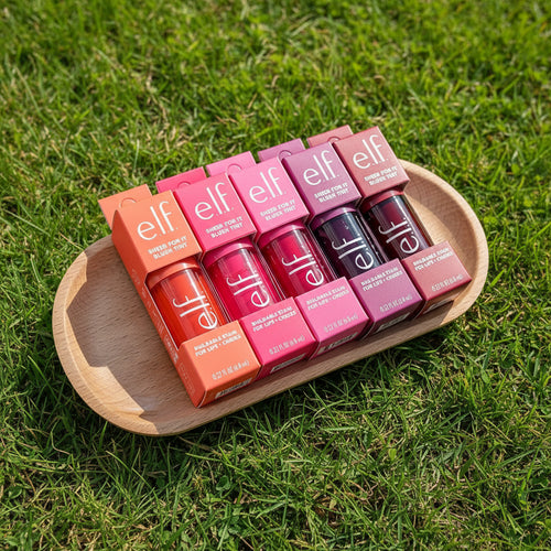 Set of e.l.f. lip products on a wooden tray with a pink and purple gradient background.